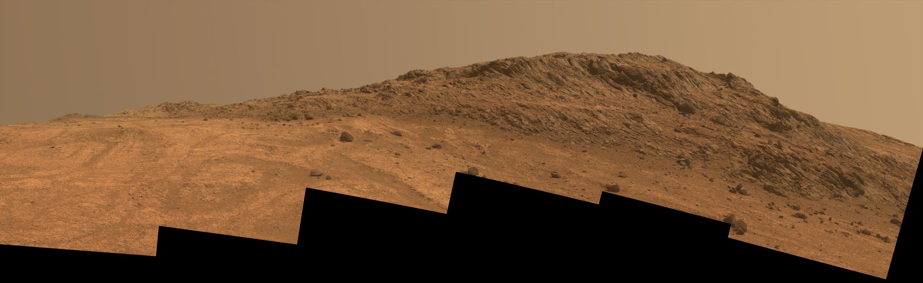A panoramic view from NASA's Opportunity rover showing a rocky ridge and ochre Martian terrain in Marathon Valley.